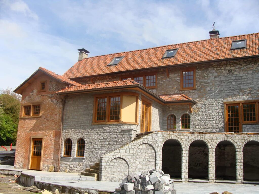 Maison en pierre rénovée avec toiture en tuiles rouges et menuiseries bois